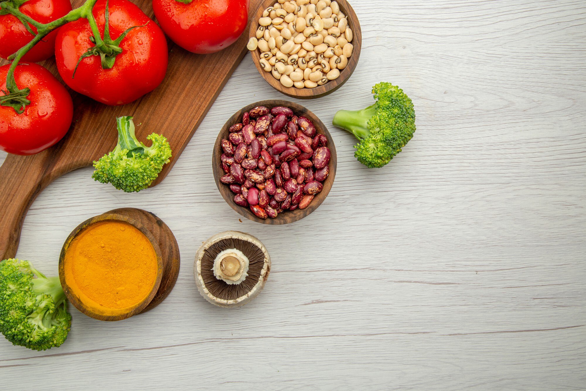 Vista superior de una mesa con platos equilibrados de verduras, granos y proteína